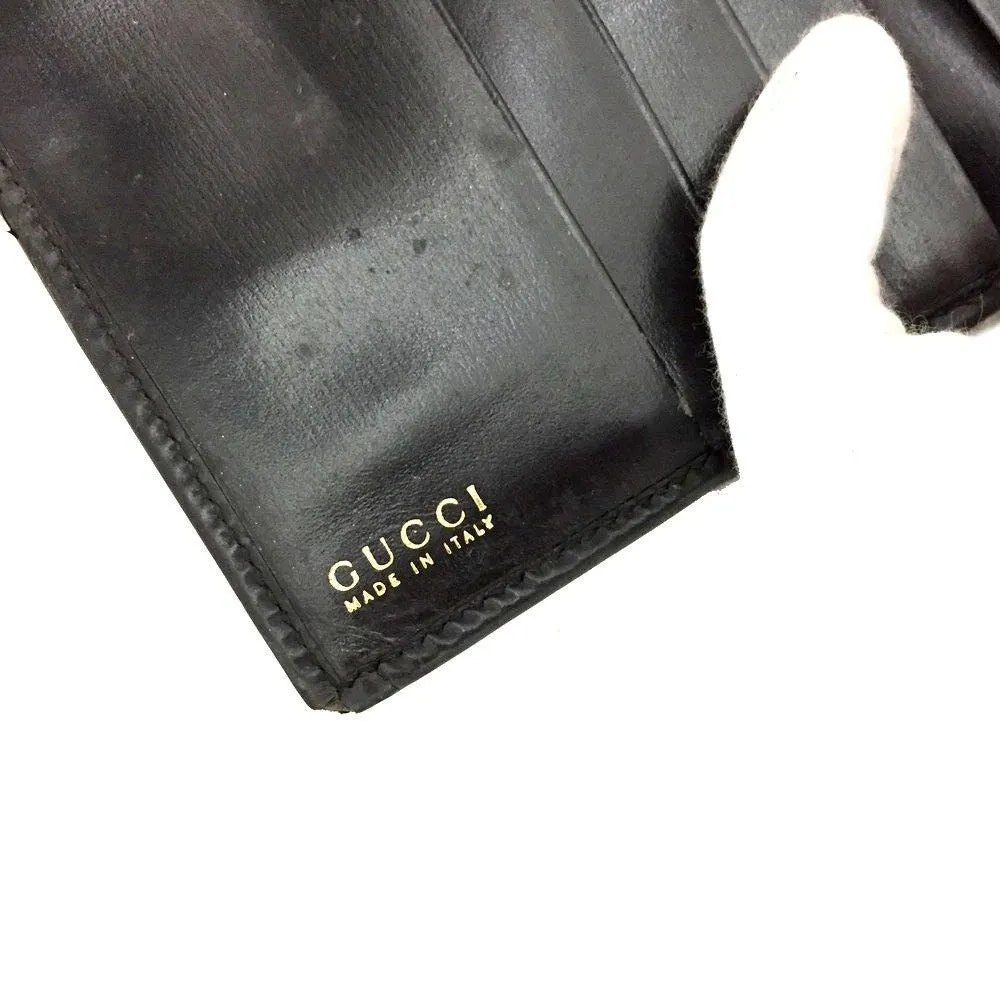 Gucci, black glossy leather, bi-fold style, rectangular, wallet with multiple pockets, tons of card slots, and a gold, hinged G clasp